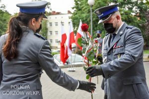 policjantka odbiera kwiat od komendanta