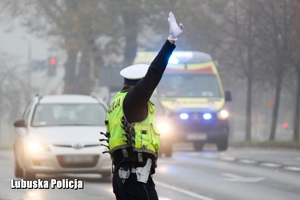 policjant kieruje ruchem na drodze w rejonie cmentarza